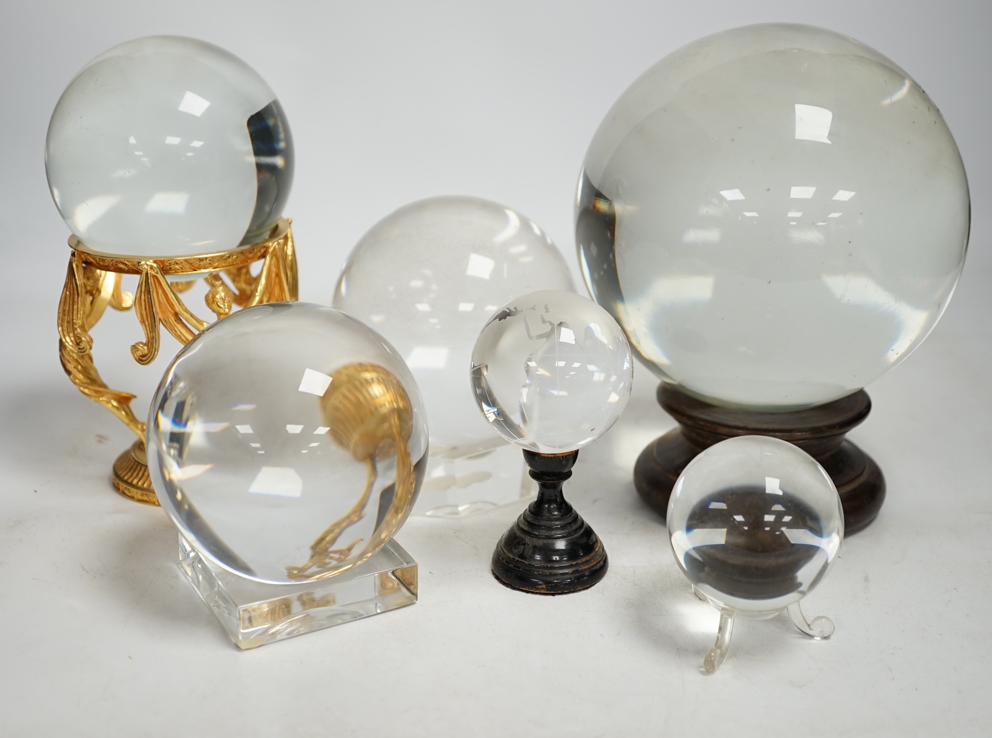 A group of six crystal balls on stands, largest 14cm across. Condition - fair